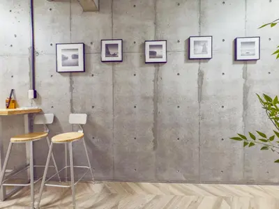 a room with stools and pictures on a concrete wall at ideas ASAKUSA Hotel in Tokyo