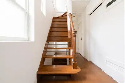 a staircase in a home with white walls and wooden floors at Luxury Tokyo Stay I 120sqm 4LDK I Close to Shibuya & Shinjuku Area in Tokyo