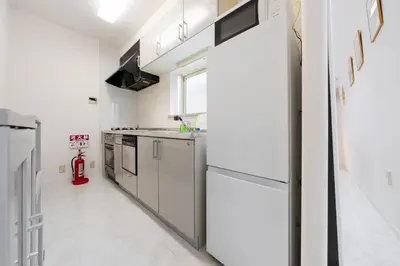 a kitchen with white appliances and a red fire extinguisher at Luxury Tokyo Stay I 120sqm 4LDK I Close to Shibuya & Shinjuku Area in Tokyo