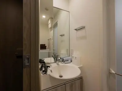 a white bathroom with a sink and a mirror at Artessimo \u62bc\u4e0a402 in Tokyo