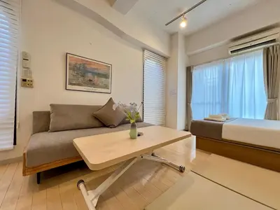 a living room with a couch and a bed at Comfy Home Kikukawa in Tokyo