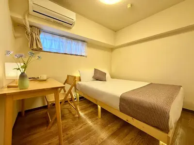 a small room with a bed and a table and a desk at Comfy Home Kikukawa in Tokyo