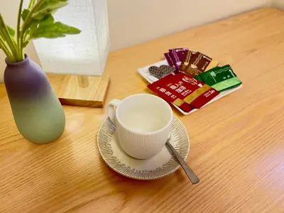 a cup and a plate on a table with a vase at Comfy Home Kikukawa in Tokyo