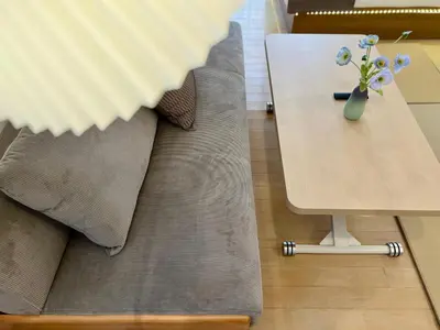 a table with a vase of flowers on top of a couch at Comfy Home Kikukawa in Tokyo