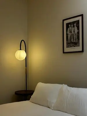 a bedroom with a bed with a lamp and a picture at \u5317\u6e0b\u8c37inn in Tokyo
