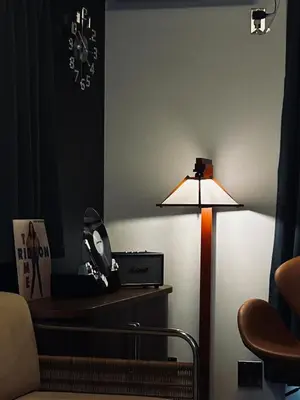 a lamp in a room with a chair and a clock at \u5317\u6e0b\u8c37inn in Tokyo