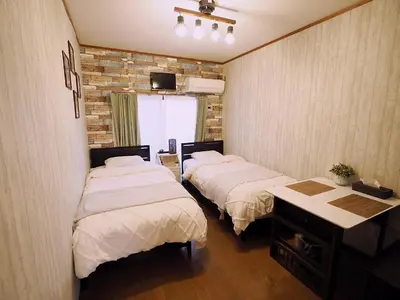 a room with two beds and a table in it at Airport and Disney direct bus Near Koiwa station in Tokyo