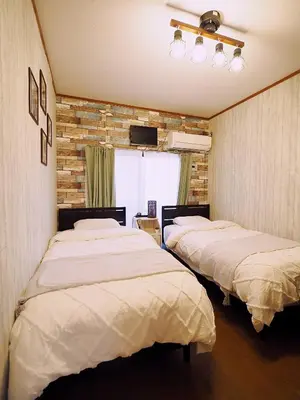 a room with two beds and a television in it at Airport and Disney direct bus Near Koiwa station in Tokyo