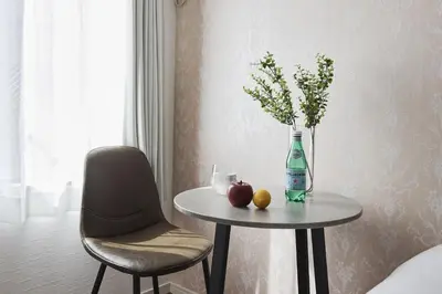 a table with a bottle and a vase of flowers and fruit at THE Dorchester β in Tokyo