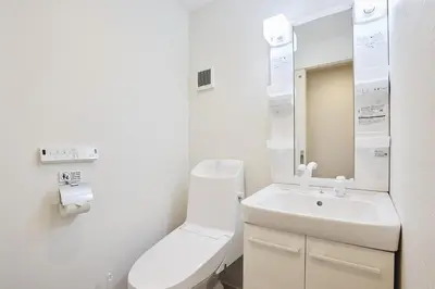 a white bathroom with a toilet and a sink at THE Dorchester β in Tokyo