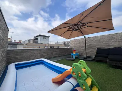 a small pool with an umbrella on a rooftop at KR family terrace in Tokyo