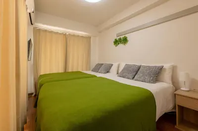 a bedroom with a large bed with a green blanket at \u30a2\u30b9\u30d4\u30a2403 in Tokyo