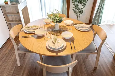 a wooden table with plates and silverware on it at tsugumi house \u3064\u3050\u307f\u4ead\u6238\u5efa\u3066\u4eac\u6210\u9ad8\u7802\u99c5 in Tokyo