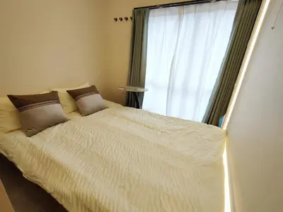 a bedroom with a large white bed with a window at C8 Shinjuku JR St 8 mins 2 bedrooms and 1 living room Max 5P Direct to Shinjuku Ueno Ginza Shibuya Ikebukuro Yoyogi Shinagawa \u65b0\u5bbf\u533a \u9ad8\u7530\u9a6c\u573a\u8f66\u7ad98\u5206\u949f \u4e24\u5ba4\u4e00\u5385 \u6700\u59275\u4eba in Tokyo