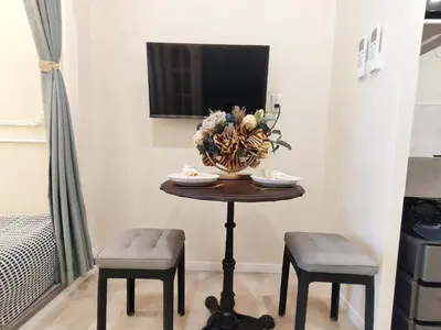 a small table with two chairs and a vase of flowers at D8 Shinjuku JR St 8 mins 2 bedrooms and 1 living room Max 5P Direct to Shinjuku Ueno Ginza Shibuya Ikebukuro Yoyogi Shinagawa \u65b0\u5bbf\u533a \u9ad8\u7530\u9a6c\u573a\u8f66\u7ad98\u5206\u949f \u4e24\u5ba4\u4e00\u5385 \u6700\u59275\u4eba in Tokyo