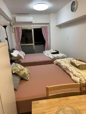 a room with three beds and a window at The Bella Ueno in Tokyo