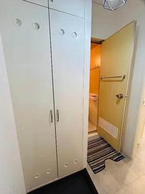 a bathroom with white cabinets and a walk in shower at The Bella Ueno in Tokyo