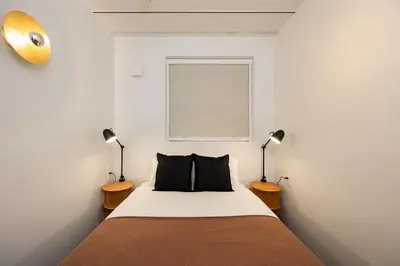 a bedroom with a bed with two lamps and a window at JAPAVISTA r4 in Tokyo