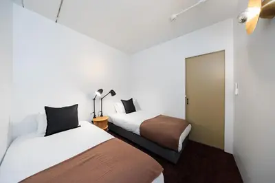 two beds in a room with white walls at JAPAVISTA r4 in Tokyo
