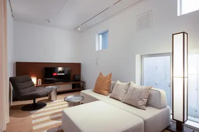 a living room with a white couch and a chair at JAPAVISTA r4 in Tokyo