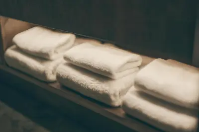 a pile of white towels on a shelf at illi Lay Shibuya-Ebisu in Tokyo