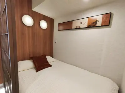 a small bedroom with a bed and two pictures on the wall at D3 Shinjuku JR St 8 mins 2 bedrooms and 1 living room Max 5P Direct to Shinjuku Ueno Ginza Shibuya Ikebukuro Yoyogi Shinagawa \u65b0\u5bbf\u533a \u9ad8\u7530\u9a6c\u573a\u8f66\u7ad98\u5206\u949f \u4e24\u5ba4\u4e00\u5385 \u6700\u59275\u4eba in Tokyo