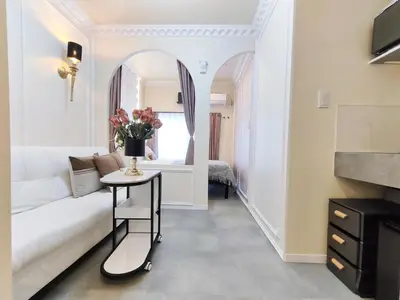 a living room with a white couch and a table with flowers at D7 Shinjuku JR St 8 mins 2 bedrooms and 1 living room Max 5P Direct to Shinjuku Ueno Ginza Shibuya Ikebukuro Yoyogi Shinagawa \u65b0\u5bbf\u533a \u9ad8\u7530\u9a6c\u573a\u8f66\u7ad98\u5206\u949f \u4e24\u5ba4\u4e00\u5385 \u6700\u59275\u4eba in Tokyo