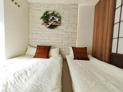 two beds sitting next to each other in a room at C2 Shinjuku JR St 8 mins 2 bedrooms and 1 living room Max 5P Direct to Shinjuku Ueno Ginza Shibuya Ikebukuro Yoyogi Shinagawa \u65b0\u5bbf\u533a \u9ad8\u7530\u9a6c\u573a\u8f66\u7ad98\u5206\u949f \u4e24\u5ba4\u4e00\u5385 \u6700\u59275\u4eba in Tokyo