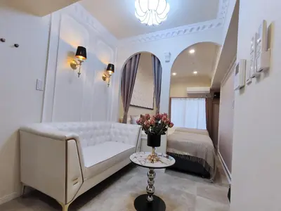 a living room with a white couch and a table with flowers at B3 Shinjuku JR St 8 mins 2 bedrooms and 1 living room Max 5P Direct to Shinjuku Ueno Ginza Shibuya Ikebukuro Yoyogi Shinagawa \u65b0\u5bbf\u533a \u9ad8\u7530\u9a6c\u573a\u8f66\u7ad98\u5206\u949f \u4e24\u5ba4\u4e00\u5385 \u6700\u59275\u4eba in Tokyo