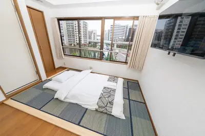 a bed in a room with a large window at \u532f\u91d1\u829d\u6d66\u30d3\u30eb in Tokyo