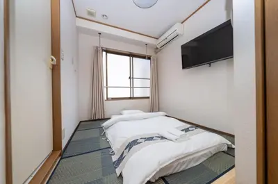 two beds in a room with a flat screen tv at \u532f\u91d1\u829d\u6d66\u30d3\u30eb in Tokyo