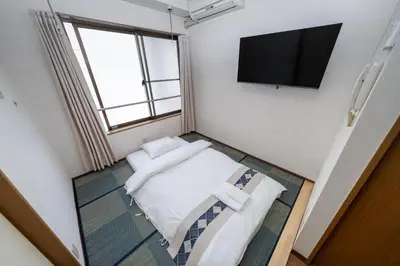 a small room with a bed and a flat screen tv at \u532f\u91d1\u829d\u6d66\u30d3\u30eb in Tokyo