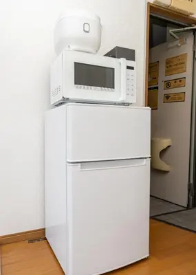 a microwave on top of a white refrigerator at \u532f\u91d1\u829d\u6d66\u30d3\u30eb in Tokyo