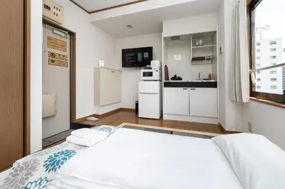 a small room with a bed and a kitchen at \u532f\u91d1\u829d\u6d66\u30d3\u30eb in Tokyo