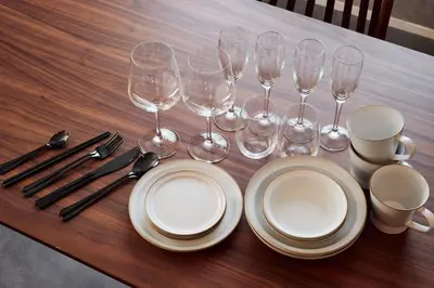 a table with plates and wine glasses and utensils at Nihonbashi Hamacho Hotel Fortuna, PH 50m2, 3min, 4pax in Tokyo