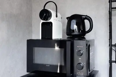 a microwave with a coffee maker on top of it at Nihonbashi Hamacho Hotel Fortuna, PH 50m2, 3min, 4pax in Tokyo