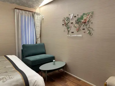 a room with a bed and a green chair and a map at GOOD DAY Shinagawa HOTEL in Tokyo