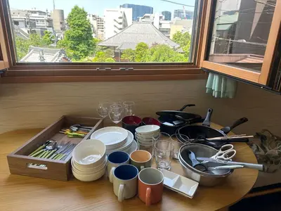 a table with plates and utensils on a table with a window at GOOD DAY Shinagawa HOTEL in Tokyo