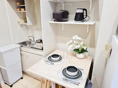 a small kitchen with a table with plates and flowers at 2\u5c64\u5b8c\u5168\u8cb8\u5207 jr\u677f\u6a4b\u99c5\u5f92\u6b692\u5206 \u6c60\u888b\u307e\u3067\u96fb\u8eca2\u5206 \u6700\u59279\u4eba in Tokyo