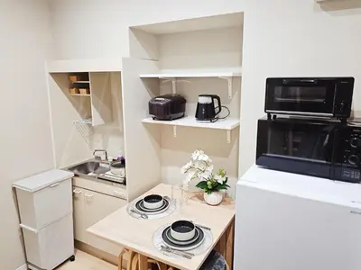 a small kitchen with a table and a microwave at 2\u5c64\u5b8c\u5168\u8cb8\u5207 jr\u677f\u6a4b\u99c5\u5f92\u6b692\u5206 \u6c60\u888b\u307e\u3067\u96fb\u8eca2\u5206 \u6700\u59279\u4eba in Tokyo