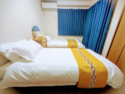 a bedroom with two beds and a blue curtain at \u6c60\u888b\u672c\u753a101 in Tokyo