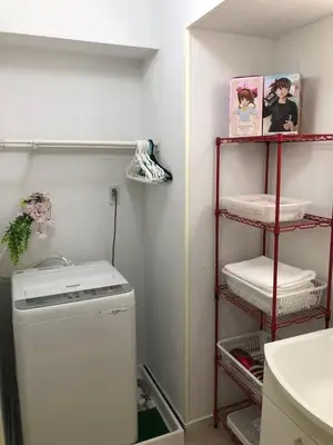 a laundry room with a washing machine and a shelf with towels at Ikebukuro-hostel池袋中川301&501-TS0038 in Tokyo