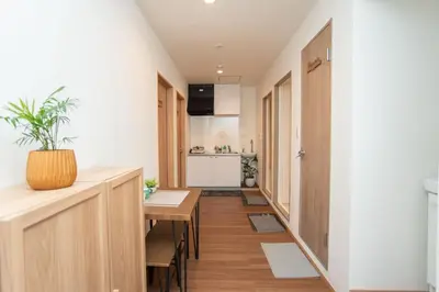 a small apartment with a hallway with a table and a kitchen at Natsumi \u30db\u30c6\u30eb 2F \u6210\u7530\u673a\u573a-\u7fbd\u7530\u673a\u573a-\u4e0a\u91ce \u4e00\u7ebf\u76f4\u8fbe in Tokyo