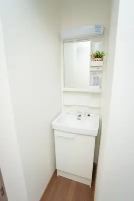 a white bathroom with a sink and a mirror at Natsumi \u30db\u30c6\u30eb 2F \u6210\u7530\u673a\u573a-\u7fbd\u7530\u673a\u573a-\u4e0a\u91ce \u4e00\u7ebf\u76f4\u8fbe in Tokyo
