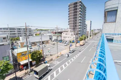 a view of a city street with a blue bridge at Natsumi \u30db\u30c6\u30eb 2F \u6210\u7530\u673a\u573a-\u7fbd\u7530\u673a\u573a-\u4e0a\u91ce \u4e00\u7ebf\u76f4\u8fbe in Tokyo