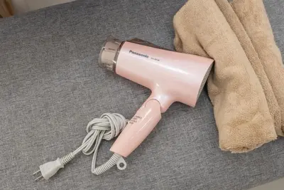 a pink hair dryer sitting on the floor next to a towel at Designer condo close to Asakusa, Tokyo Skytree in Tokyo