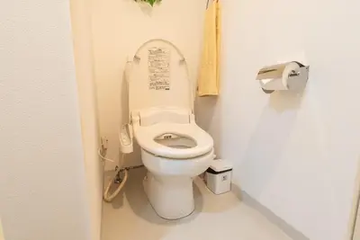 a white toilet in a bathroom with a phone at Designer condo close to Asakusa, Tokyo Skytree in Tokyo