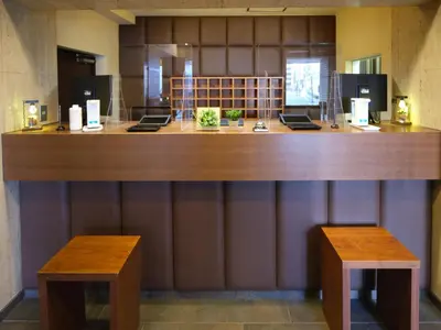 a lobby with a large wooden counter with two benches at POD SELECT HOTEL SHINJUKU - Vacation STAY 43662v in Tokyo