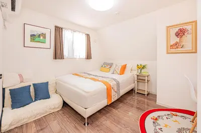 a white bedroom with a bed and a couch at Stay cozy - Vacation STAY 43532v in Tokyo