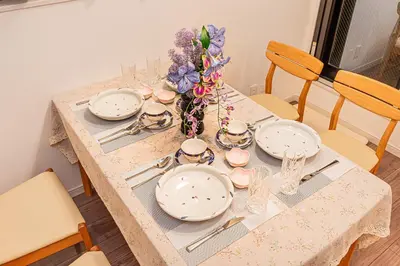 a table with plates and a vase of flowers on it at Stay cozy - Vacation STAY 43532v in Tokyo
